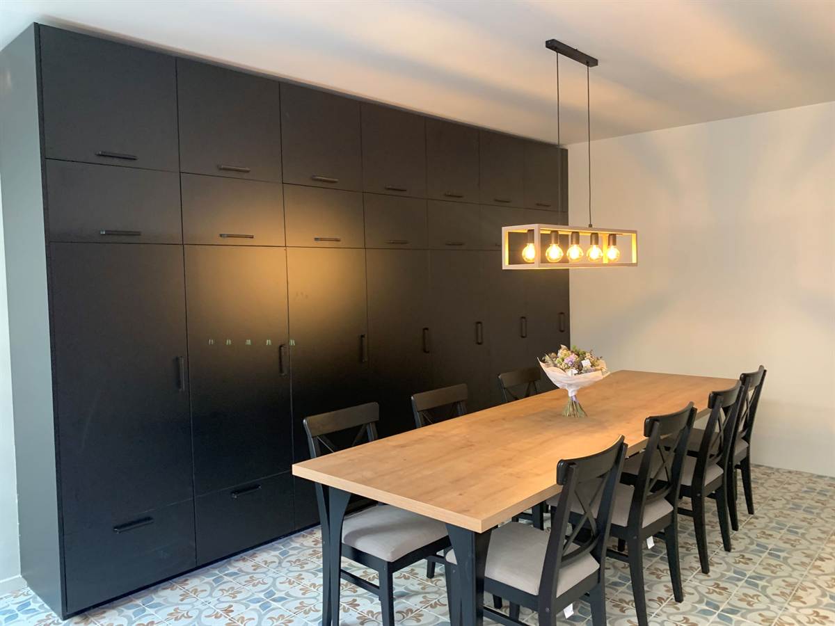 Salle à manger, grande table de chêne devant le mur des sept réfrigérateurs.